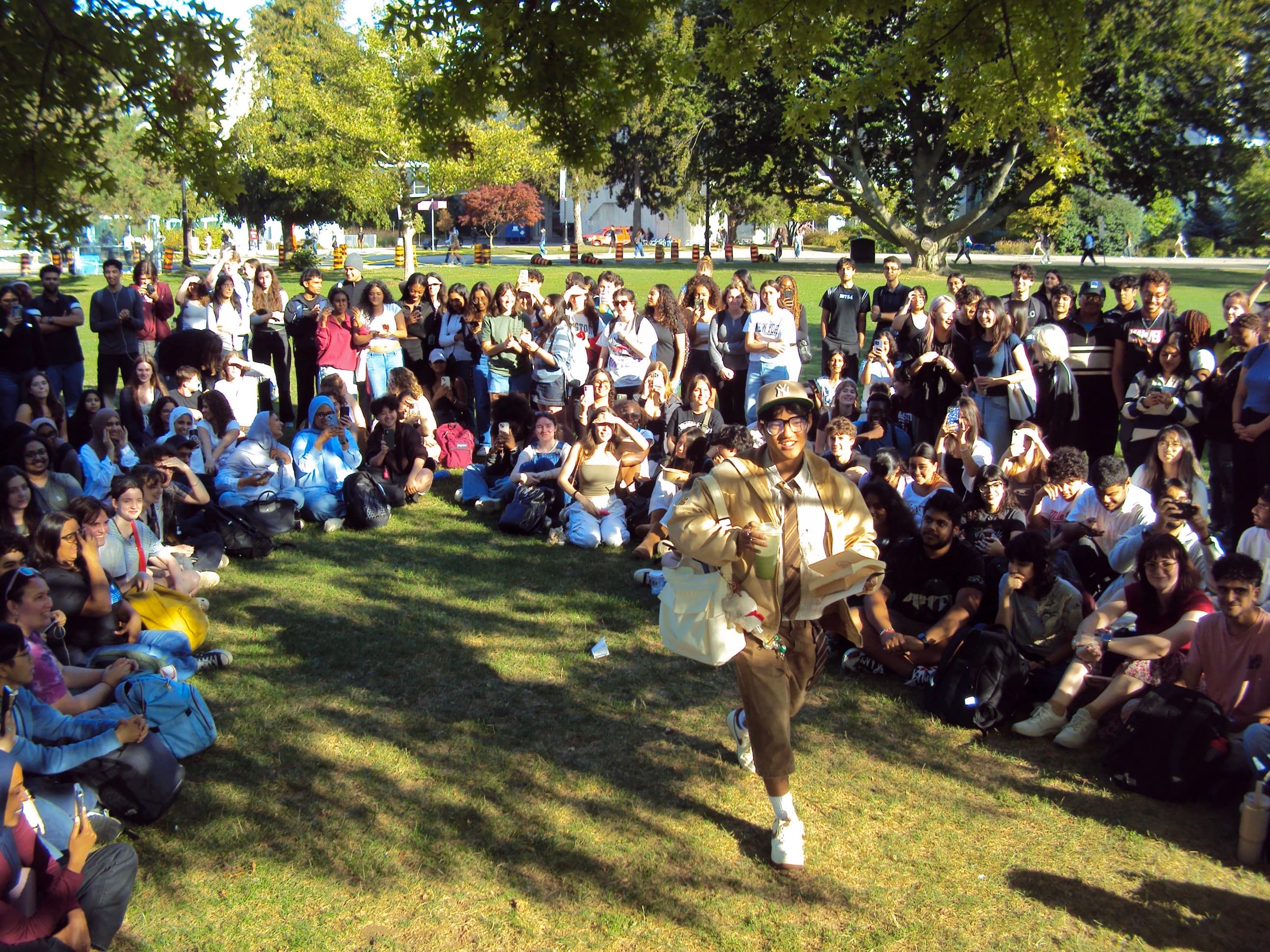 A model walking through a crowd on a sunny lawn