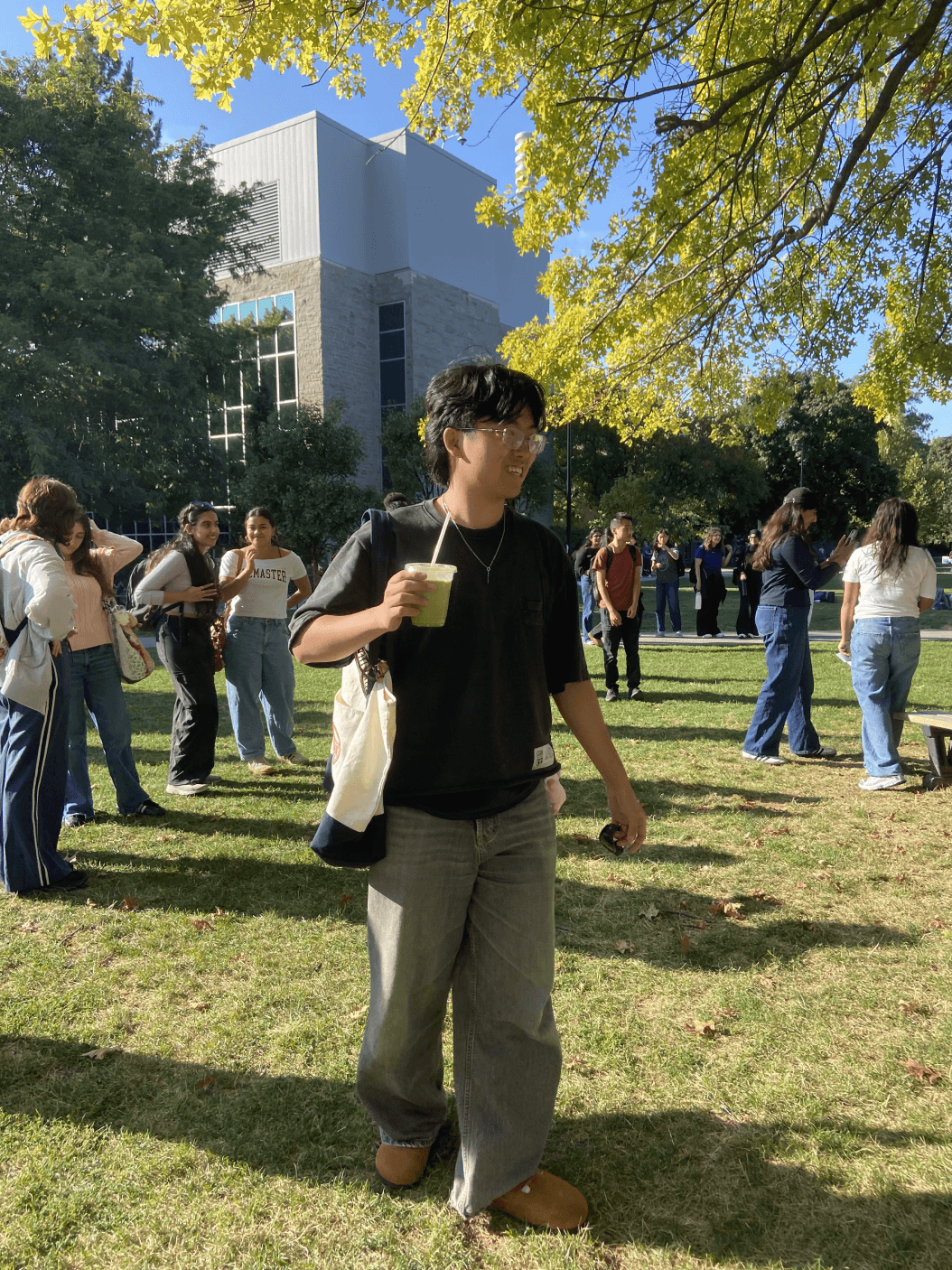 A student carrying a matcha drink at the campus event